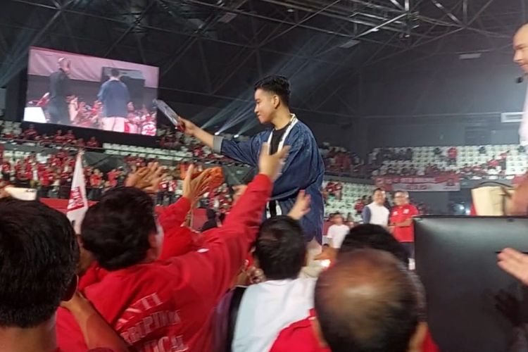 Wali Kota Solo Gibran Rakabuming Raka membagikan kaos di acara Kopi Darat Nasional (Kopdarnas) Partai Solidaritas Indonesia (PSI) di Tennis Indoor, Senayan, Jakarta, Selasa (22/8/2023) malam.