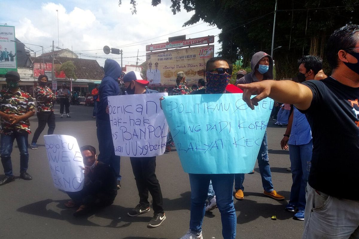 Massa melakukan aksi unjuk rasa memrotes pemutusan kontrak tenaga banpol Satpol PP Kota Blitar di depan Balai Kota Blitar, Senin (29/3/2021)