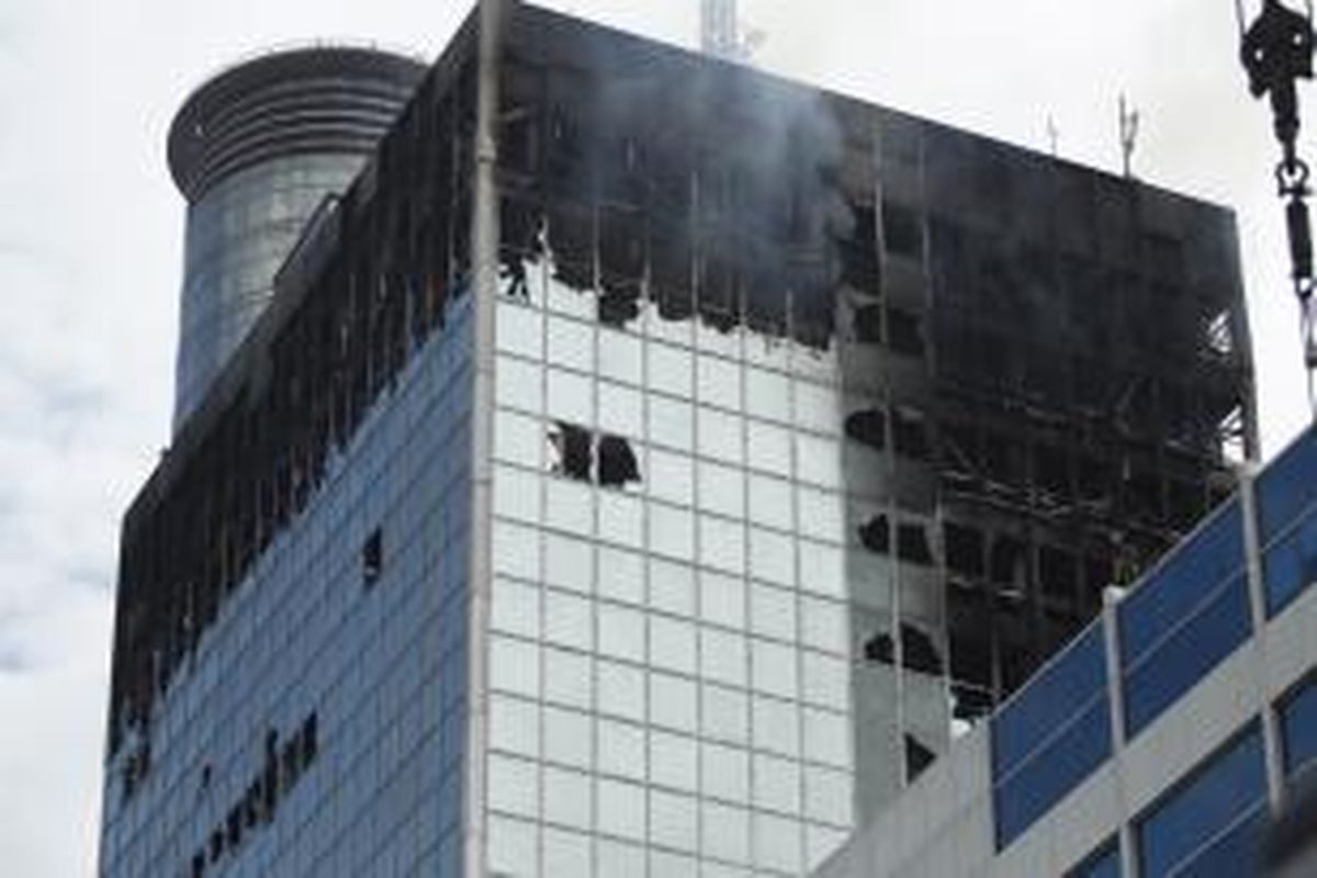 Kondisi gedung Wisma Kosgoro yang terbakar, di Jalan MH Thamrin, Jakarta, Selasa (10/3/2015). Kebakaran yang terjadi pada Senin malam ini bermula dari lantai 16 dan merembet ke lantai 20. Penyebab kebakaran masih ditelusuri.
