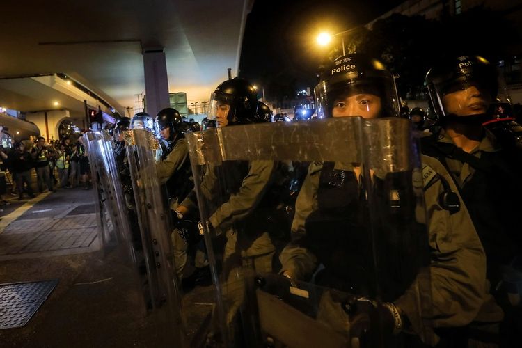 Pasukan polisi antihuru-hara yang diterjunkan untuk menghalau massa pengunjuk rasa di Hong Kong, pada Minggu (21/7/2019).