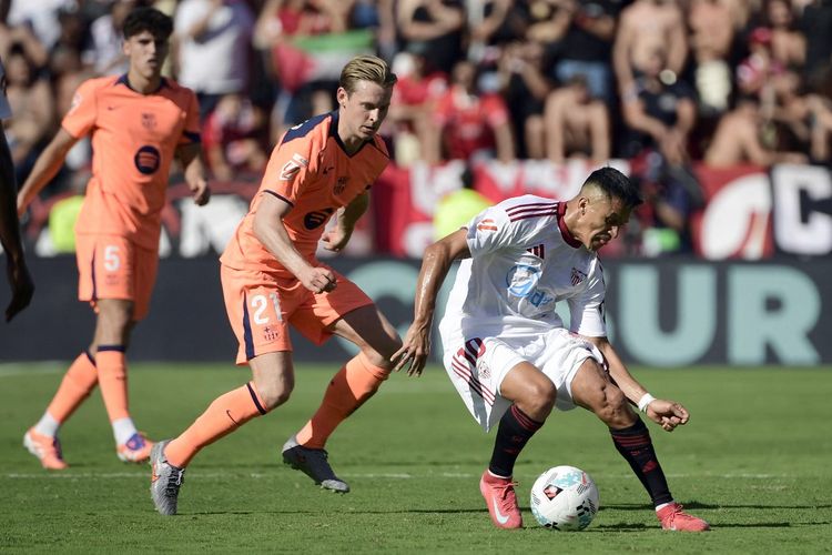 Alexis Sanchez (kanan) dibayangi Frenkie De Jong dalam pertandingan sepak bola Liga Spanyol antara Sevilla vs Barcelona di Stadion Ramon Sanchez Pizjuan di Seville pada 5 Oktober 2025. (Foto oleh CRISTINA QUICLER / AFP)