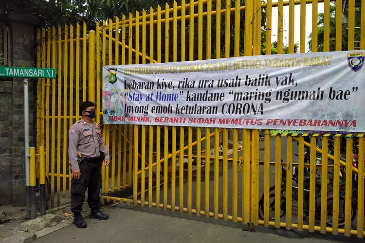 Pemasangan spanduk dilarang mudik oleh anggota polisi dari Polsek Metro Tamansari, Jakarta Barat, Senin (27/4/2020)