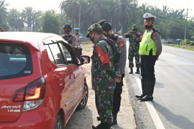 Petugas kepolisian dan TNI melakukan pemeriksaan terhadap kendaraan yang keluar masuk di perbatasan Riau-Sumut, Kamis (29/4/2021).