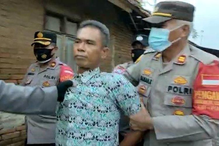 Polisi saat mengamankan seorang terduga pelaku yang menewaskan 2 petani tebu warga Majalengka pada lahan tebu PG Jatitujuh di Desa Amis, Kecamatan Cikedung, Kabupaten Indramayu, Senin (4/10/2021).