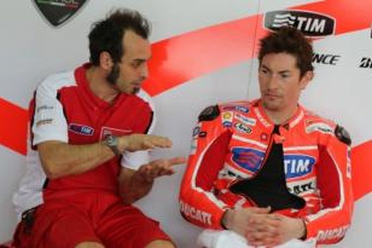 Pebalap Ducati, Nicky Hayden (kanan) berdiskusi dengan manajer tim, Vittoriano Guareschi, pada uji coba resmi pertama di Sepang, Malaysia, Februari 2013. 