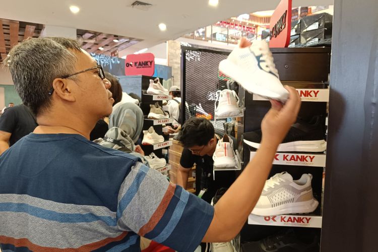 Seorang pengunjung sedang melihat-lihat sepatu di acara Urban Skena Fest di Bandung.