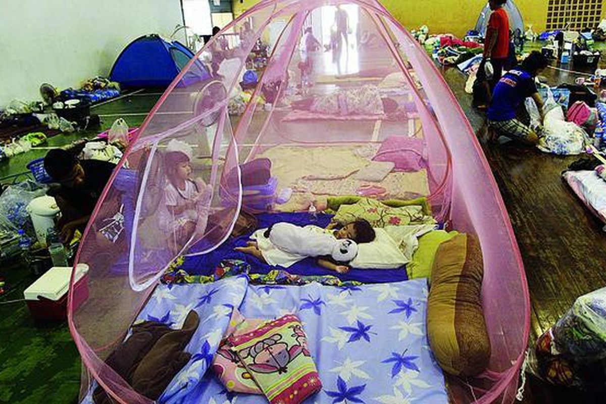 Keluarga Thailand tidur di bawah jaring-jaring nyamuk di tempat pengungsian di distrik  Bangkhunthian, Bangkok, Thailand, Selasa (15/11). Perdana Menteri Thailand Yingluck Shinawatra meminta rakyat sabar dalam menghadapi banjir, yang diperkirakan masih akan cukup lama bertahan.
