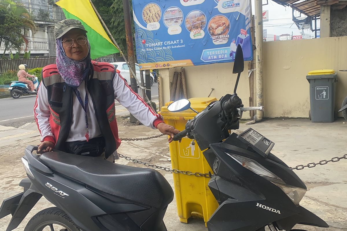 Eti Sumiati (52 tahun) saat tengah memarkirkan kendaraan yang akan keluar dari mini market di Kecamatan Cisaat, Kabupaten Sukabumi, Jawa Barat. Kamis (17/4/2025).