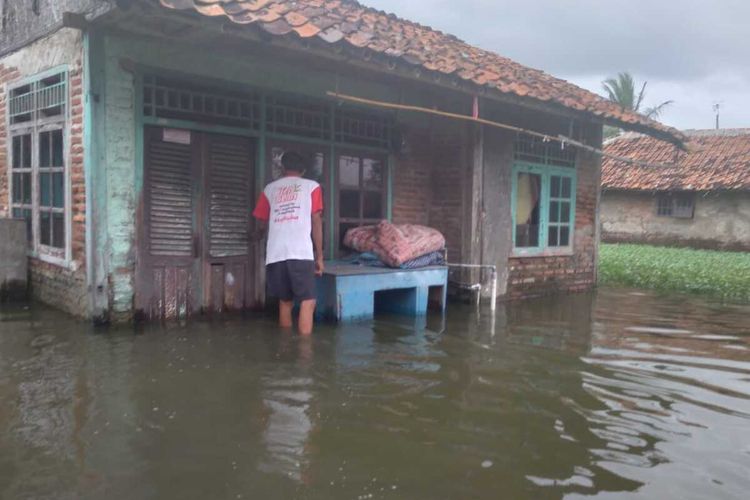 Seorang warga di Rengasdengklok Utara, Kecamatan Rengasdengklok tengah meninjau rumah yang terdampak banjir pada 4 Februari 2021.