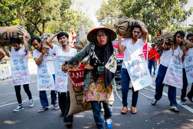 Buruh melakukan aksi teatrikal pada hari buruh internasional atau May Day dengan berunjuk rasa di sekitar Istana Merdeka, Jakarta, Selasa (1/5/2018). Dalam aksinya mereka menuntut pemerintah untuk menurunkan harga beras, listrik, BBM, membangun ketahanan pangan dan ketahanan energi, menolak upah murah, mencabut Peraturan Pemerintah Nomor 78 tahun 2015 tentang pengupahan, dan merealisasikan 84 item Kebutuhan Hidup Layak (KHL) serta menolak tenaga kerja asing.