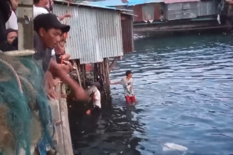 Warga di kawasan Pasar Batu Merah Ambon menangkap kawanan ikan bubara yang terjebak di sungai tersebut, Sabtu (1/5/2021)