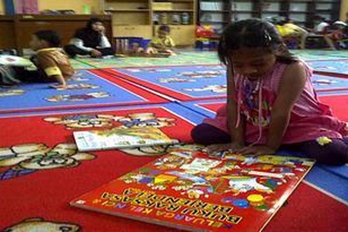 Srengenge (5), asyik membaca buku di perpustakaan daerah Jawa Tengah, untuk mengisi liburannya.