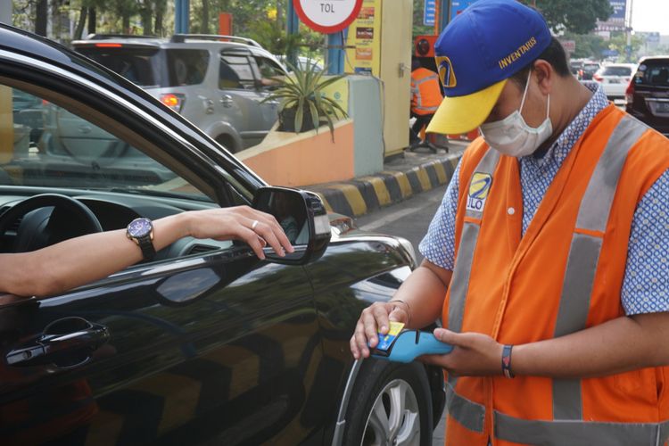 Petugas GT Toll pasteur tengah melayani pengemudi yang hendak masuk ke GT Tol Pasteur, di Bandung, Senin (25/12/2017) dengan alat pembaca uang elektronik portabel.