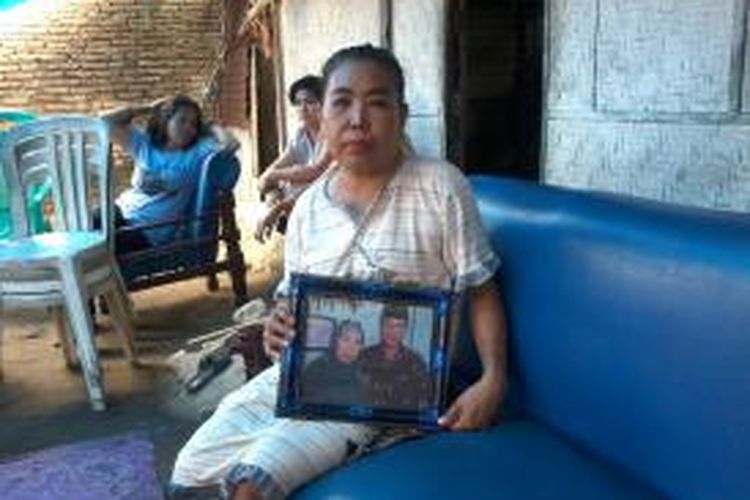 Batriana Daeng Bau memperlihatkan foto almarhum suaminya Husaini Daeng Sikki yang tewas setelah diculik tiga orang yang mengaku polisi