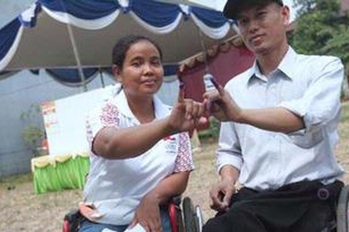 Penyandang disabilitas, Laeli dan Ridwan menunjukkan tinta di jarinya usai memberikan hak pilih nya di TPS 058 Cilandak Barat, Jakarta Selatan, Rabu (11/7/2012).