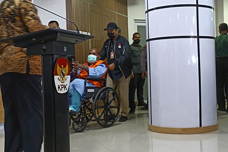 Gubernur Papua Lukas Enembeengenakan rompi oranye bertuliskan tahanan Komisi Pemberantasan Korupsi (KPK).