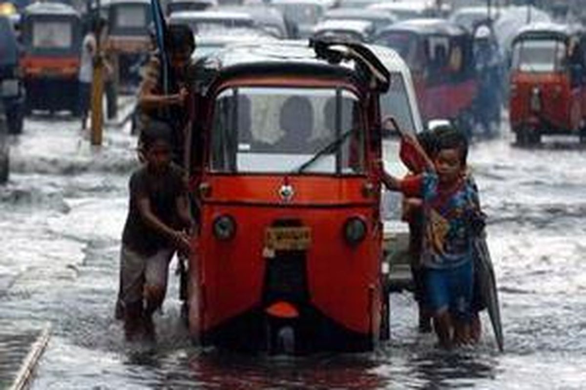 Genangan air akibat hujan deras menyebabkan beberapa kendaraan mogok.