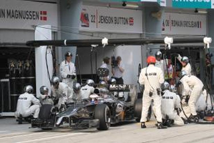 Pebalap McLaren asal Inggris, Jenson Button memasuki pit Sirkuit Sepang saat GP Malaysia, Minggu (30/3/2014).