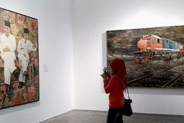 Pengunjung memotret lukisan di pameran lukisan Art & Toilet yang digelar hingga 3 Mei 2015, di Galeria Fatahillah, Taman Fatahillah, Kota Tua, Jakarta, Sabtu (7/2/2015). Pameran itu menyajikan lukisan pemandangan Jakarta tempo dulu karya asli para maestro dari masa 1920-an hingga sekarang.