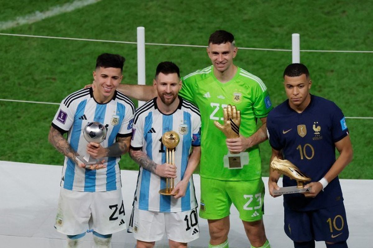 Gelandang Argentina Enzo Fernandez (kiri), penyerang Lionel Messi, penjaga gawang Emiliano Martinez, dan penyerang Perancis Kylian Mbappe berpose di podium setelah masing-masing menerima penghargaan Pemain Muda, Sarung Tangan Emas, Sepatu Emas, dan Bola Emas, pada acara trofi Piala Dunia 2022 Qatar usai pertandingan final antara Argentina vs Perancis di Stadion Lusail di Lusail, utara Doha pada Minggu 18 Desember 2022.