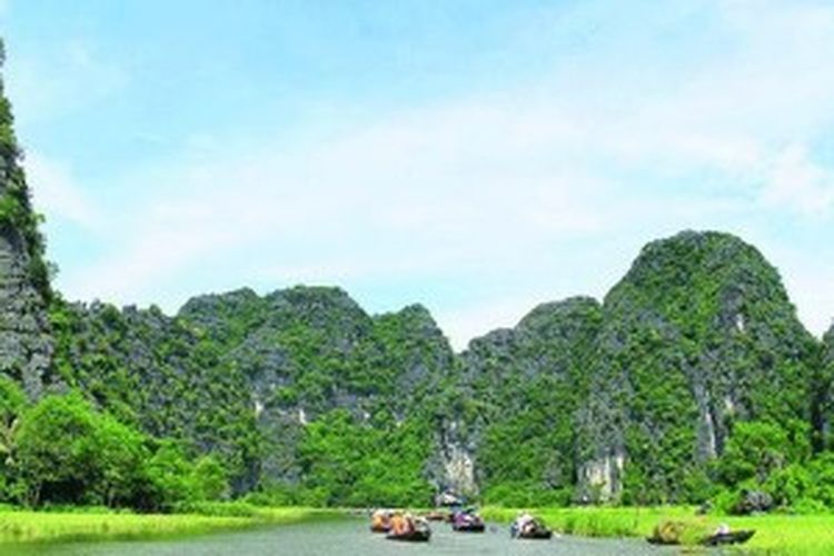 Wisata air berperahu di Sungai Ngo Dong alias Tam Coc. Pengunjung dapat melihat keindahan gugusan batuan kapur tua lebih dekat dari sungai.