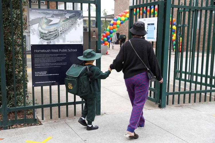 Anak-anak kembali ke sekolah setelah untuk kali pertama sekolah umum New South Wales dibuka kembali sepenuhnya untuk semua siswa dan staf di tengah pelonggaran pembatasan penyakit Covid-19 di Homebush West Public School di Sydney, Australia, Senin (25/5/2020). 