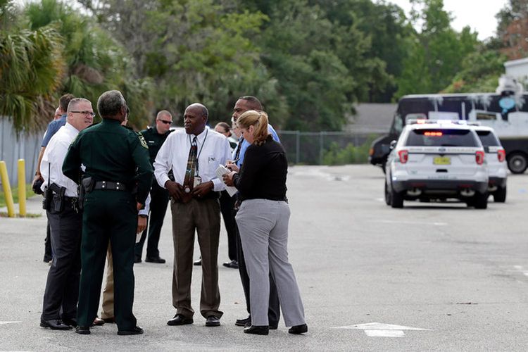 Sejumlah petugas dan aparat penegak hukum sedang berkumpul di luar kawasan bisnis dekat Orlando , Florida, Senin (5/6/2017), Senin (5/6/2017), usai aksi penembakan yang dilakukan seorang warga, hingga menewaskan lima orang. Pelaku mengakhiri serangan itu dengan menghabisi nyawanya sendiri.