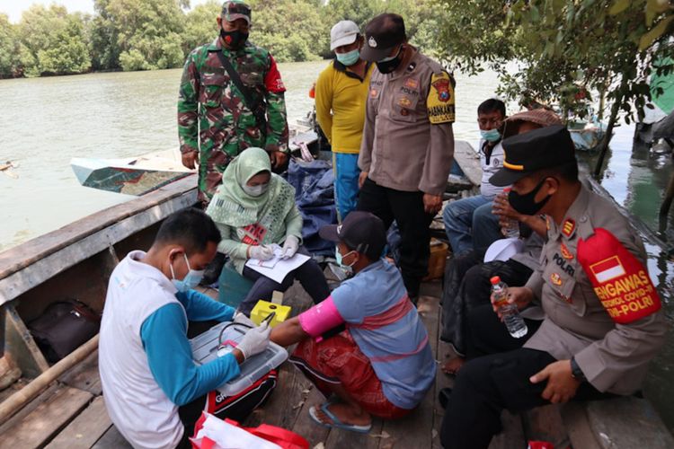 Petugas saat memberikan vaksinasi kepada para nelayan di atas perahu, Jumat (15/10/2021).