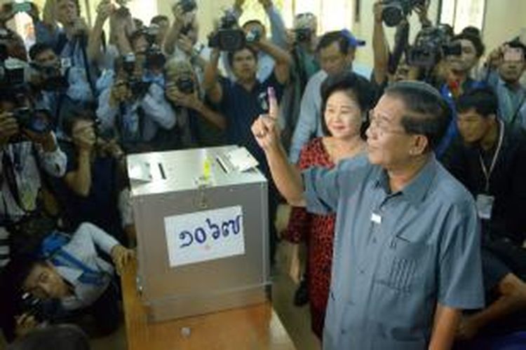 Perdana Menteri Kamboja Hun Sen memamerkan telunjuknya yang sudah bertinta, sebagai tanda dia sudah menggunakan hak pilih dalam pemilu, Minggu (28/7/2013). Hun Sen dan istrinya, Bun Rany, memilih di salah satu tempat pemungutan suara di Provinsi Kandal.
