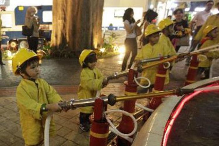 Anak-anak berprofesi sebagai pemadam kebakaran saat bermain di Kidzania, Pacific Place, Jakarta, Senin (5/8/2013).  