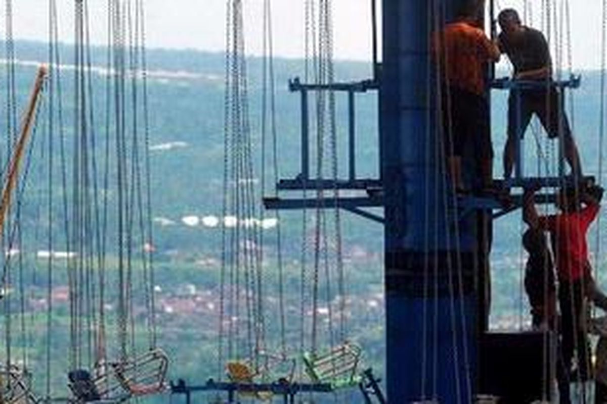 Para pekerja memasang wahana permainan di sebuah arena bermain dan wisata malam di Kelurahan Oro-oro Ombo, Kota Batu, Jawa Timur, Kamis (16/12/2010). Tempat wisata berlomba-lomba menghias diri untuk menyambut pengunjung, memanfaatkan momentum libur Natal dan Tahun Baru.