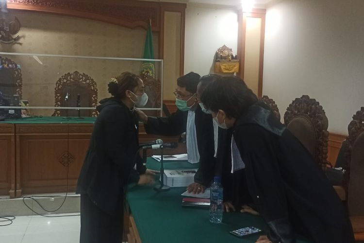 Mantan Bupati Tabanan, Ni Putu Eka Wiryastuti (46), saat berdiskusi dengan tim penasehat hukumnya di Pengadilan Tipikor Denpasar, Bali pada Kamis (11/8/2022). Kompas.com/ Yohanes Valdi Seriang Ginta