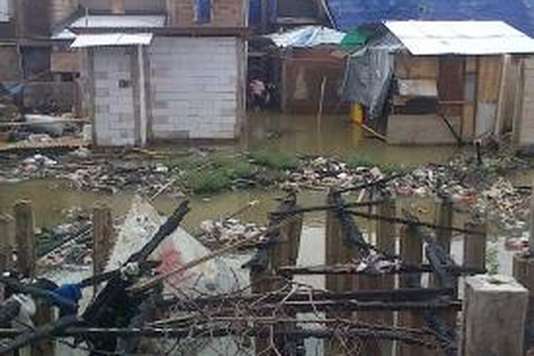 Genangan air dan sampah masuk ke rumah-rumah warga di Kampung Kandang, Kelurahan Kelapa Gading Barat, Kecamatan Kelapa Gading, Jakarta Utara, Jumat (17/1/2014). Banjir terjadi akibat hujan yang terjadi sejak dini hari tadi.
