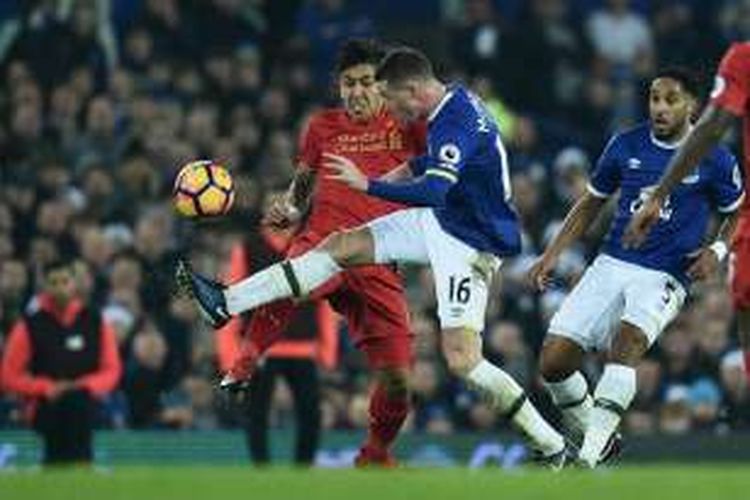 Pemain Liverpool, Roberto Firmino (kiri), berduel dengan pemain Everton, James McCarthy, dalam lanjutan Premier League di Stadion Goodison Park, Senin (19/12/2016) waktu setempat.