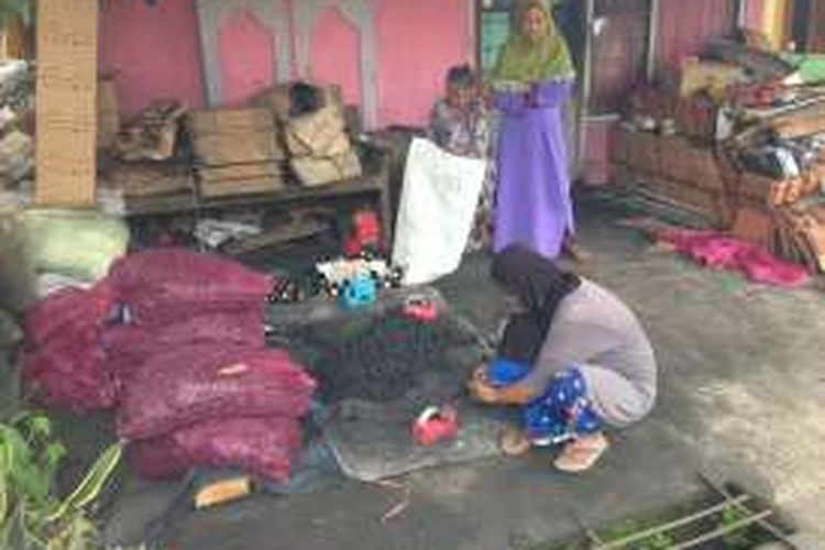 Warga Salamkrep mengemasi briket dari yang dihasilkan dari tempurung kelapa. Tiap kotak, warga diberi upah Rp 55.