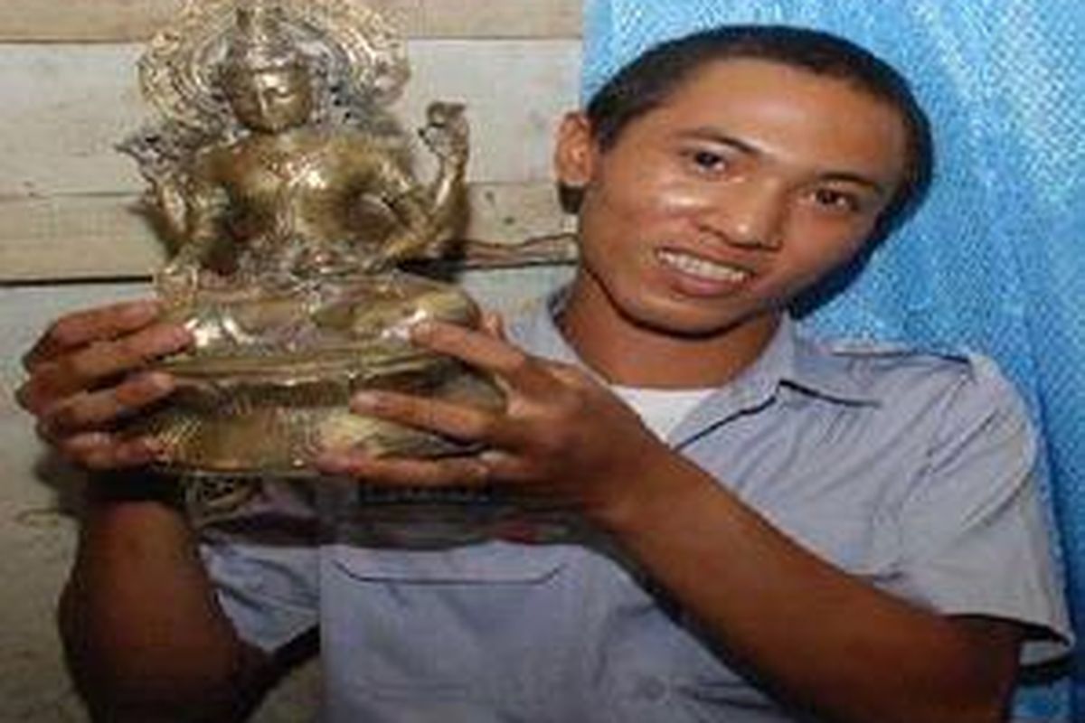 Alex Anggara, warga Jl Ogan, Bukit Besar, bersama Arca Wisnu yang ditemukan di samping rumahnya, pada bulan Ramadhan tahun lalu, Jumat (13/3).