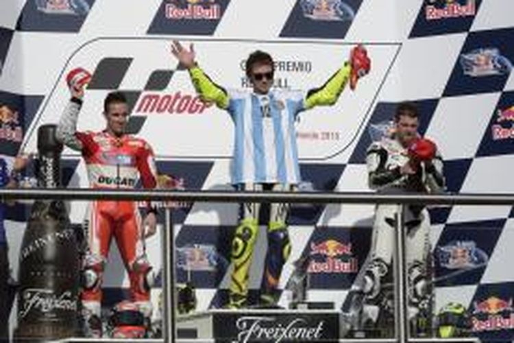 Pebalap Movistar Yamaha asal Italia, Valentino Rossi (tengah), berdiri di atas podium Sirkuit Termas de Rio Honda, setelah memenangi GP Argentina, Minggu (19/4/2015). Pebalap Ducati asal Italia, Andrea Dovizioso (kiri), dan pebalap CWM LCR Honda asal Inggris, Cal Crutchlow, finis kedua dan ketiga.