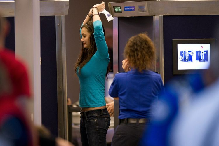 Seorang pelancong wanita menjalani pemindaian seluruh tubuh sebelum menuju ke penerbangannya di Bandara Internasional Pittsburgh, 24 November 2010.