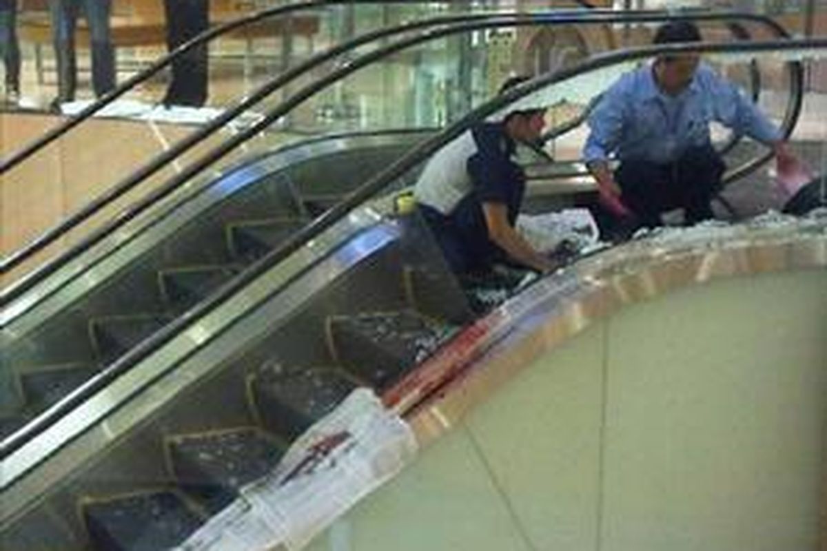 Petugas sedang membersihkan lokasi jatuhnya korban di lantai UG (upper ground) Mal Grand Indonesia