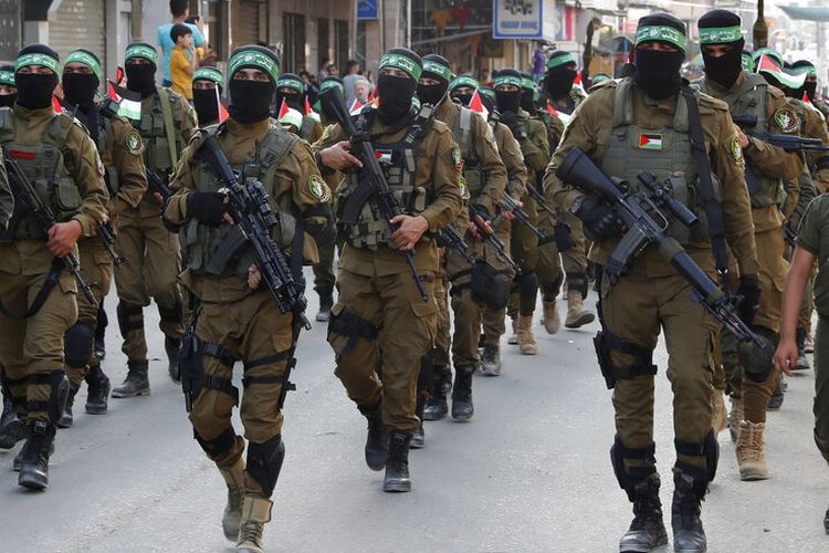 Militan dengan penutup wajah dari Brigade Izzedine al-Qassam, sayap militer Hamas, berbaris di sepanjang jalan kamp pengungsi Nusseirat, Jalur Gaza tengah, Jumat, 28 Mei 2021.