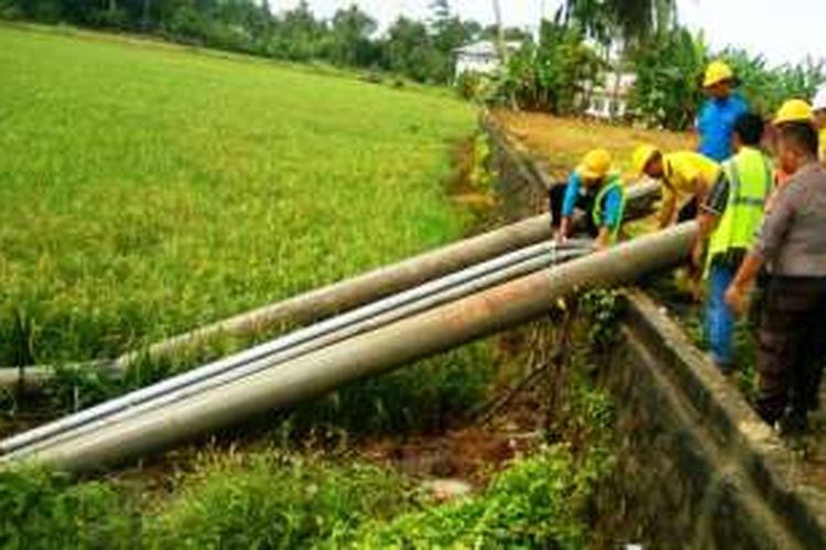 Pekerja PLN dan polisi sedang berusaha memperbaiki tiang yang tumbang akibat angin kencang di Desa  Alue Bilie Rayeuk, Kecamatan Baktiya, Aceh Utara, Senin (2/1/2017)