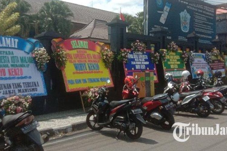 Papan ucapan karangan bunga berjejer rapi di depan Polresta Malang Kota. Papan ucapan itu merupakan apresiasi dari masyarakat atas keberhasilan penangkapan pelaku penipuan investasi robot trading ATG, Wahyu Kenzo. 