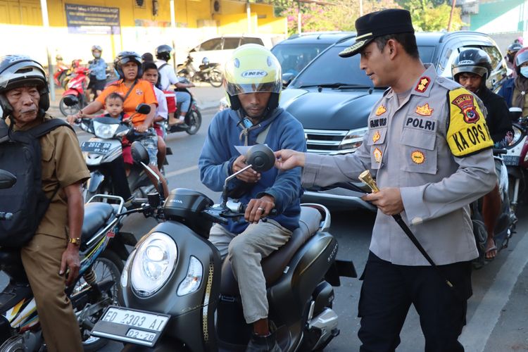 Kapolres Sumba Timur Ajun Komisaris Besar Polisi (AKBP) Fajar Widyadharma, turun ke jalan sambil menyebarkan pamflet yang isinya imbauan tentang bahaya Tindak Pidana Perdagangan Orang (TPPO), kepada para pengendara di Kota Waingapu, ibu kota Kabupaten Sumba Timur, Senin (5/6/2023) 