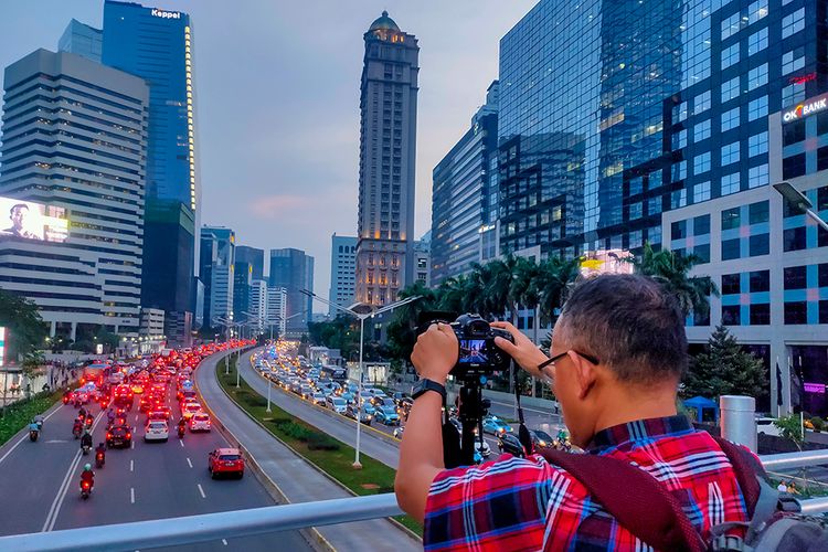 Seorang fotografer bernama Yonatan yang berburu foto di JPO tanpa atap Sudirman.