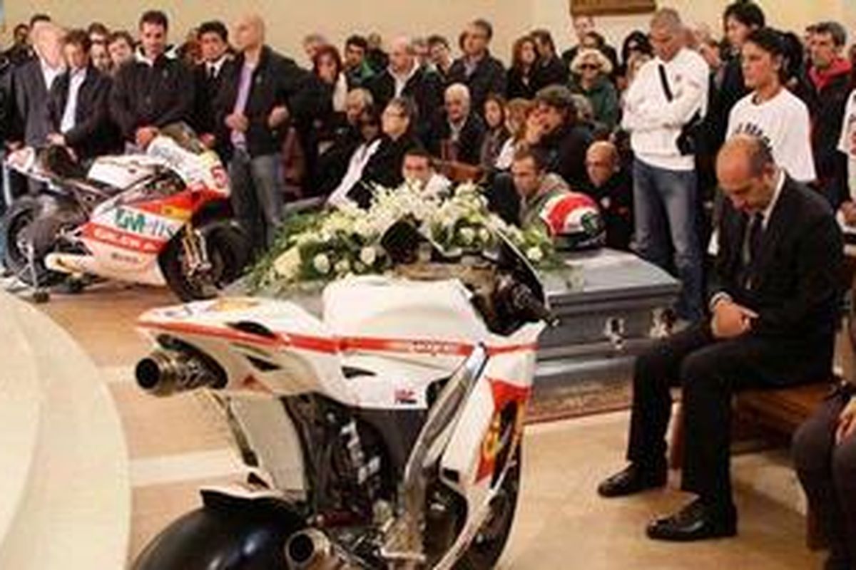 Helm dan motor yang ada di samping peti jenazah, saat upacara pemakaman Marco Simoncelli, Kamis (27/10/11). Simoncelli tewas dalam kecelakaan maut GP Malaysia, Minggu (23/10/11).