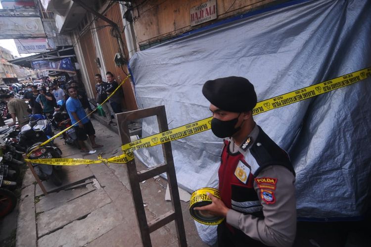 Seorang polisi berjaga di lokasi ambruknya ruko tiga lantai di Kompleks Pasar Lima, Jalan Pasar Baru, Banjarmasin, Kalsel, Selasa (27/9/2022). 