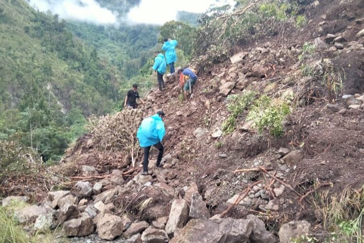 Warga desa di Mamuju saat mencoba membersihkan material longsor di Desa Karataun, Kecamatan Kalumpang, Mamuju, Sulbar.