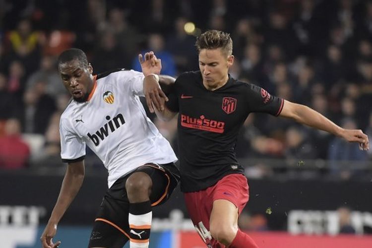 Gelandang Valencia, Geoffrey Kondogbia, berduel dengan pemain Atletico Madrid, Marcos Llorente, pada laga pekan ke-24 Liga Spanyol yang digelar di Estadio de Mestalla, Sabtu (15/2/2020).