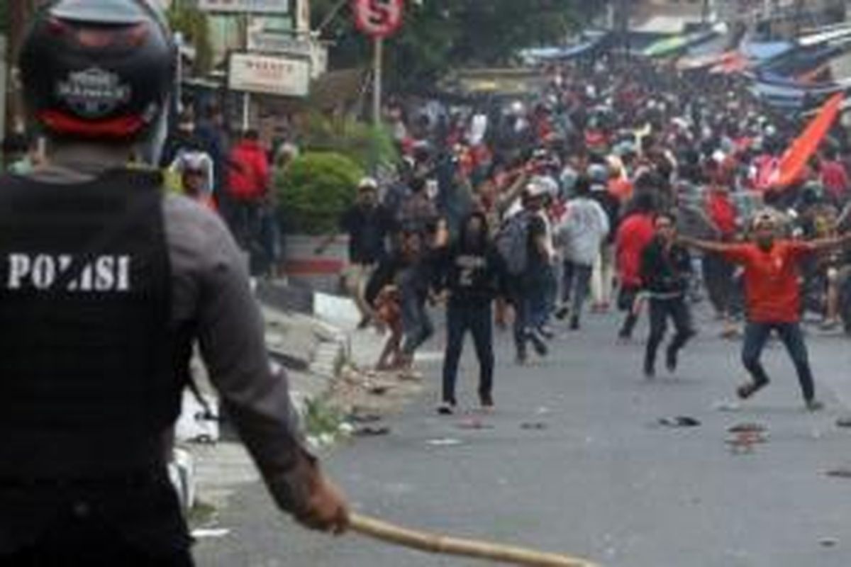 Petugas mencoba menghalau ratusan pendukung Persija Jakarta (Jakmania) yang akan mencoba masuk ke area Gelora Bung Karno di Kawasan Palmerah, Jakarta Pusat, Minggu (18/10/2015).