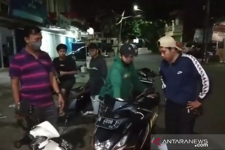 Polisi berseragam bebas memeriksa kelengkapan surat izin dari salah satu pengendara balapan liar di Jalan H Kardi, Malaka, Duren Sawit, Jakarta Timur, Rabu (9/12/2020). 
